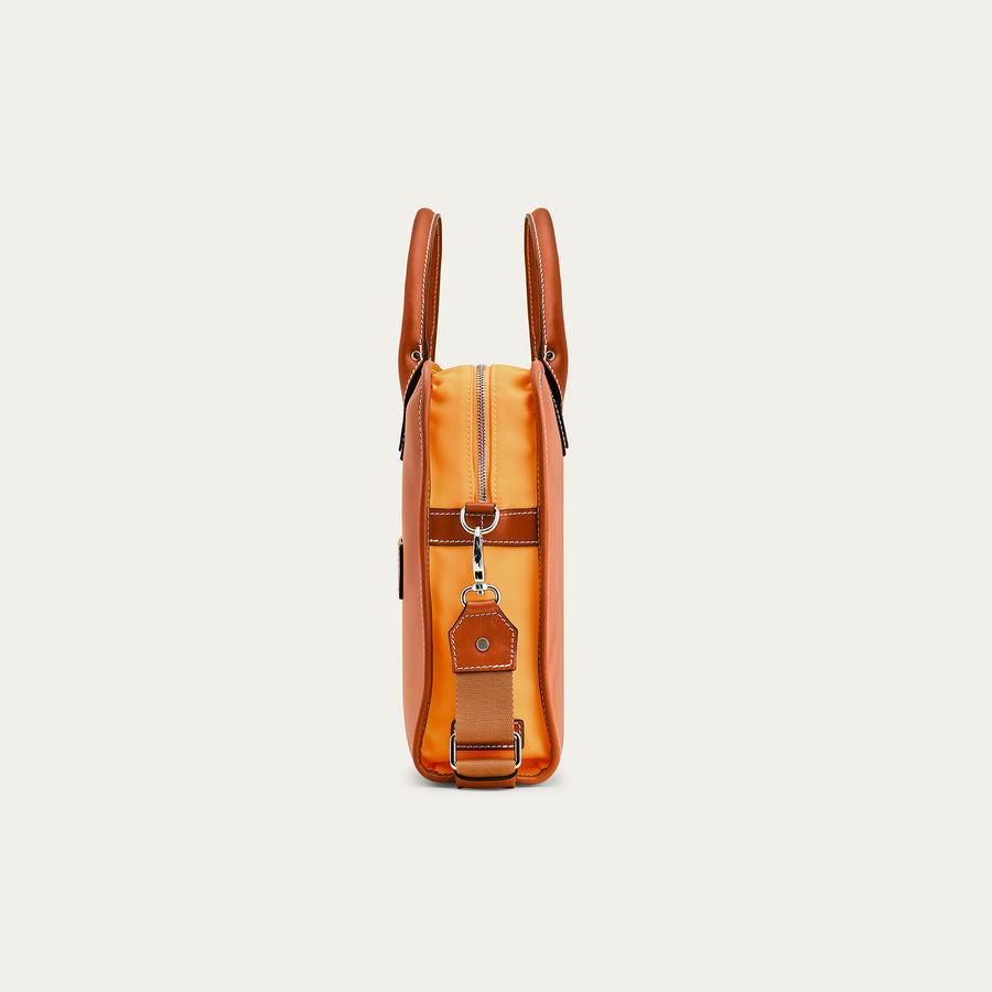 side view of a tan leather briefcase on a light beige background.