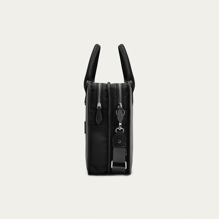 Black backpack with multiple zippers on a light gray background