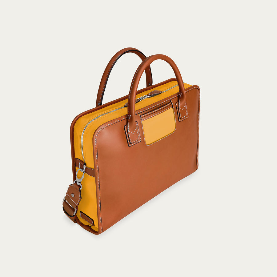Brown and yellow leather briefcase on a light beige background